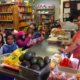 学生は小さな市場で食品について学びます。