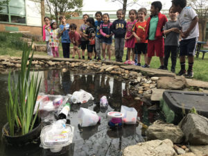 students observe plastic in school pond