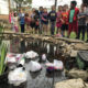 生徒は学校の池でプラスチックを観察します