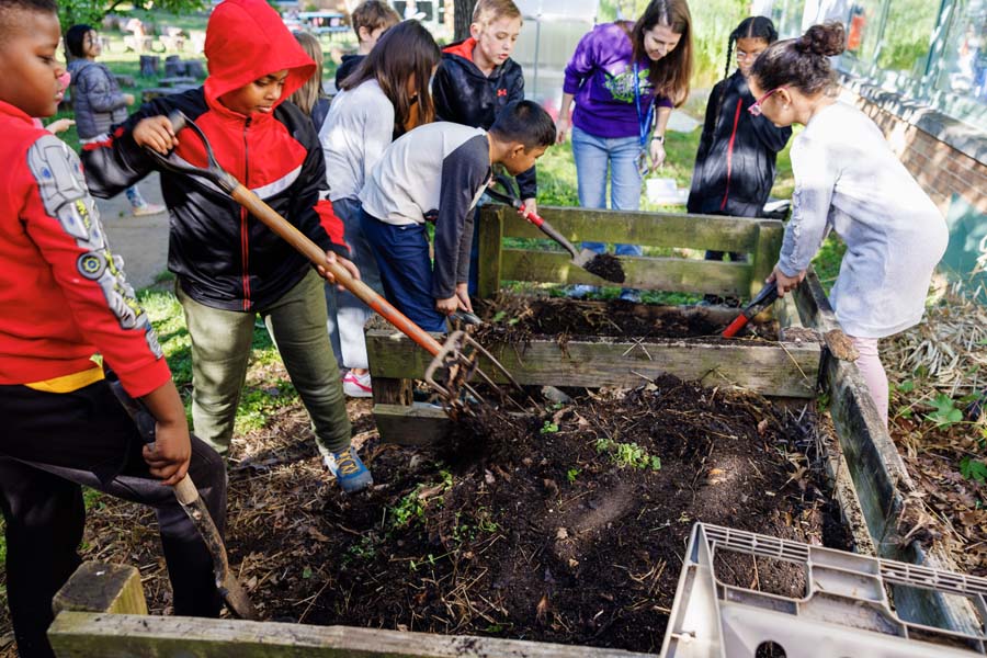 students turning compost