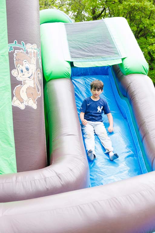 child going down inflatable slide