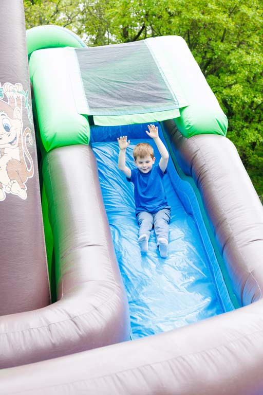 child going down inflatable slide