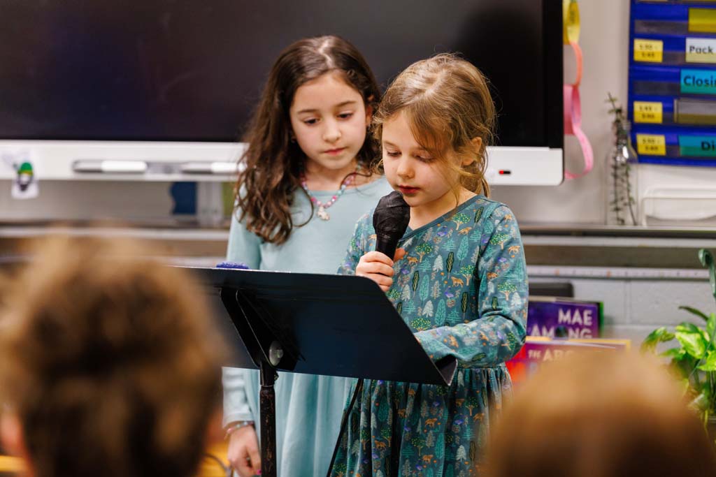 students reading to audience